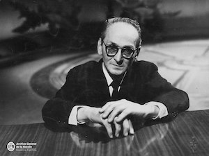 Black and white photo of Osvaldo Pugliese leaning on a grand piano